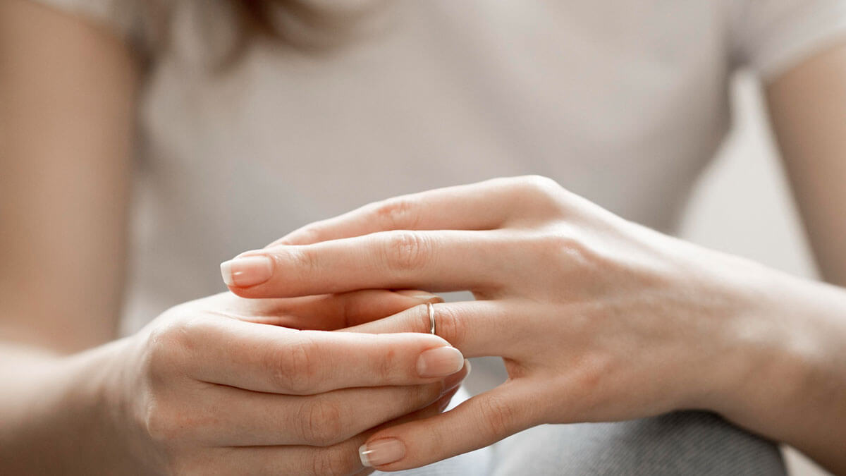 divorce-proceedings-blog26 Woman holding her wedding ring, representing contemplation of divorce proceedings