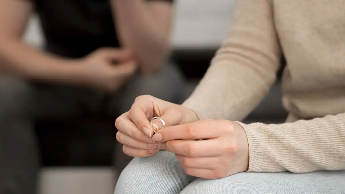 divorce-blog-jun26 Person holding their wedding ring, considering divorce